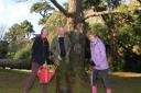 Sidmouth Arboretum's Diana East with local residents Martin McInerney and Sue Dent with two young Monterey pines that will be planted at Knowle in Sidmouth. They are pictured in front of one of the iconic Monterey pines believed to be around 150 years old