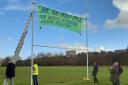 Exeter's Extinction Rebellion group installs a banner as part of its protest over approved plans for a 3G playing pitch on Flowerpot Playing Fields.