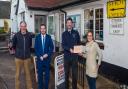 From the left:  Jeremy Wakeling, chairman of the Otterton Community Shop,  Simon Jupp MP,  Toby Russell from Air Ambulance and Nikki Butt the shop manager presenting the cheque.