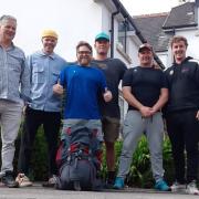 Michael Butler is in the middle and James, to his left, are in the team taking on the 100km walk along the Jurassic Coast