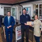 From the left:  Jeremy Wakeling, chairman of the Otterton Community Shop,  Simon Jupp MP,  Toby Russell from Air Ambulance and Nikki Butt the shop manager presenting the cheque.