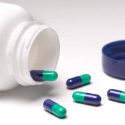 Capsules left lying on table, with open pill bottle