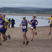 Winning Woman Claire Stone in the 1st mile on the beach
