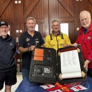 Exmouth RNLI Fundraising Treasurer, Dave Atkinson; Shop Manager, Dave Britten, Coxswain; Steve Hockings-Thompson amd Tour Guide, Ken Clayton with the scroll